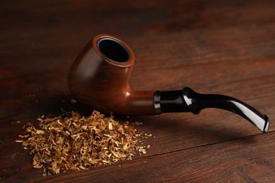 Photo of Pile of tobacco and smoking pipe on wooden table