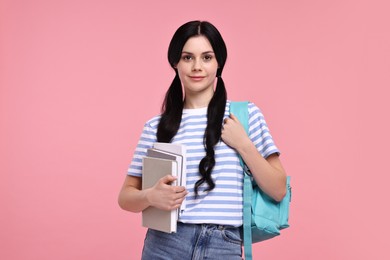 Photo of Student with books and backpack on pink background