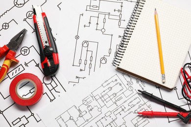 Photo of Tools and office stationery on wiring diagrams, top view