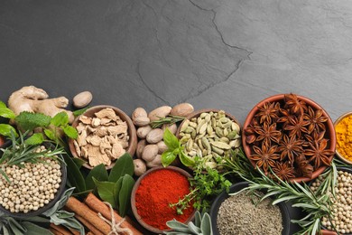 Photo of Different herbs and spices on black table, flat lay. Space for text