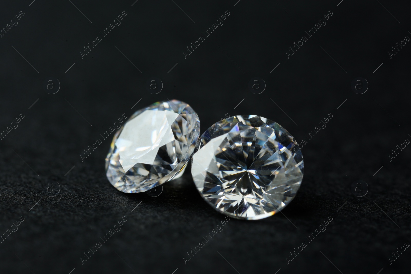 Photo of Two beautiful shiny diamonds on black background