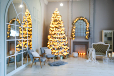 Photo of Festive room interior with stylish furniture and beautiful Christmas tree, blurred view