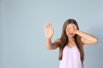 Photo of Young woman being blinded on grey background, space for text