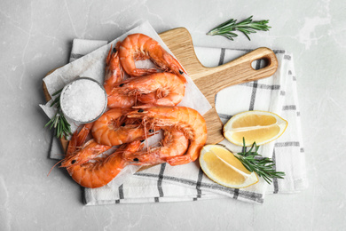 Photo of Delicious cooked shrimps served with lemon and salt on grey marble table, flat lay