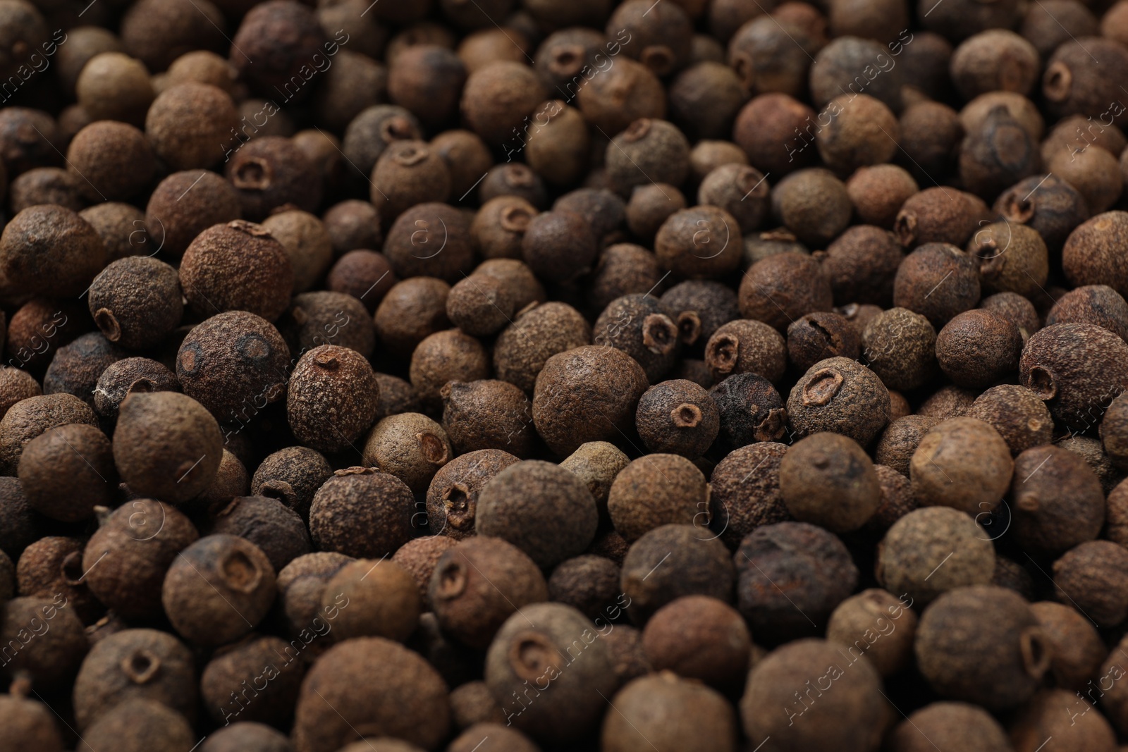 Photo of Aromatic allspice pepper grains as background, closeup view