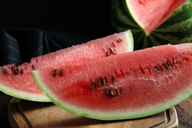 Photo of Yummy watermelon slices on wooden table, closeup