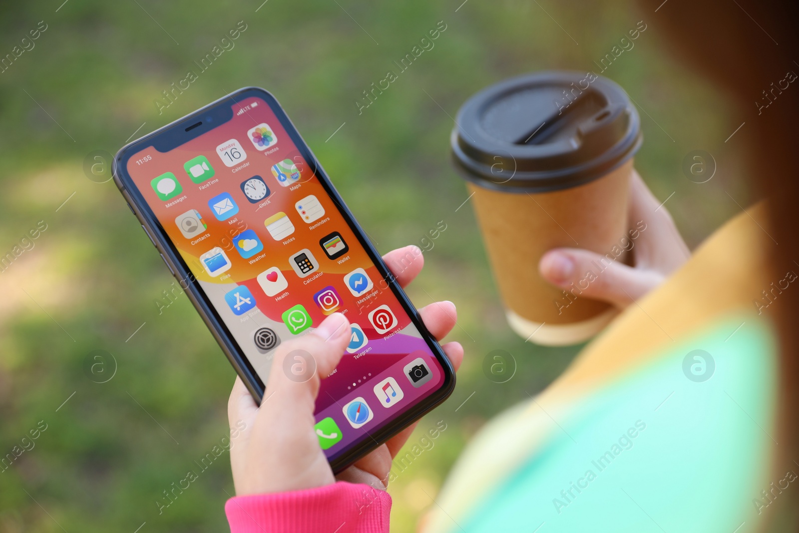 Photo of MYKOLAIV, UKRAINE - MARCH 16, 2020: Woman holding iPhone 11 with home screen outdoors, closeup