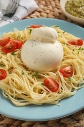 Photo of Plate of delicious pasta with burrata and tomatoes on table, closeup