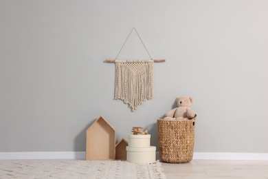 Photo of Beautiful children's room with grey wall, decor elements and toys. Interior design