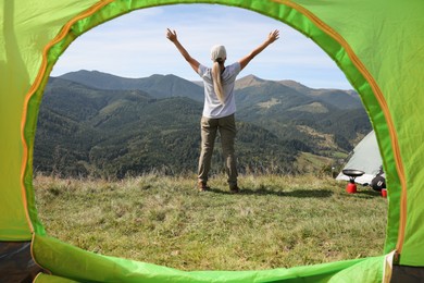 Photo of Woman enjoying mountain landscape, view from camping tent