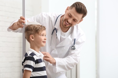 Photo of Doctor measuring little boy's height in hospital