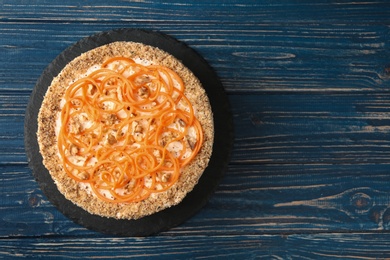 Photo of Dish with delicious carrot cake on blue wooden background, top view. Space for text