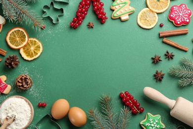 Photo of Frame of Christmas cookies, fir tree and flour on green background, flat lay. Space for text