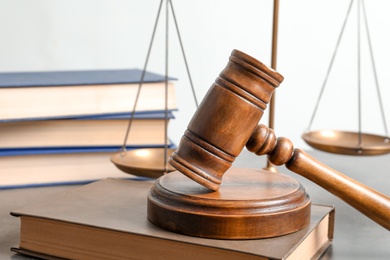 Photo of Wooden gavel, scales of justice and books on table. Law concept