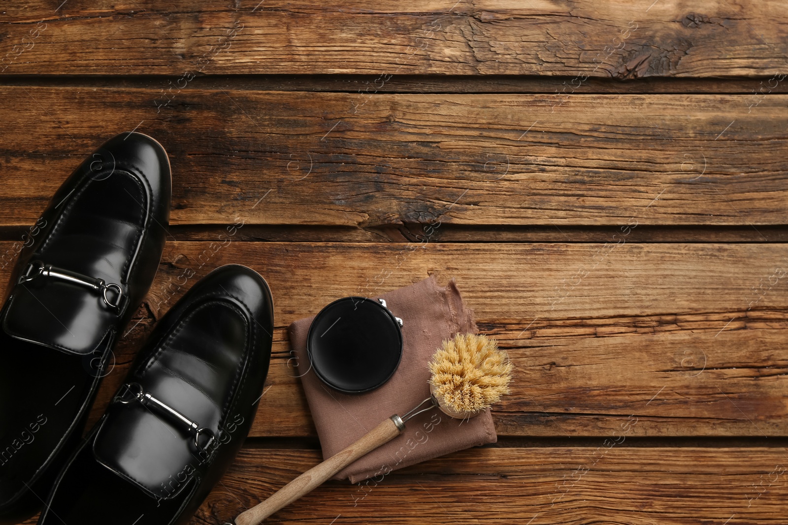 Photo of Flat lay composition with shoe care accessories and footwear on wooden background. Space for text