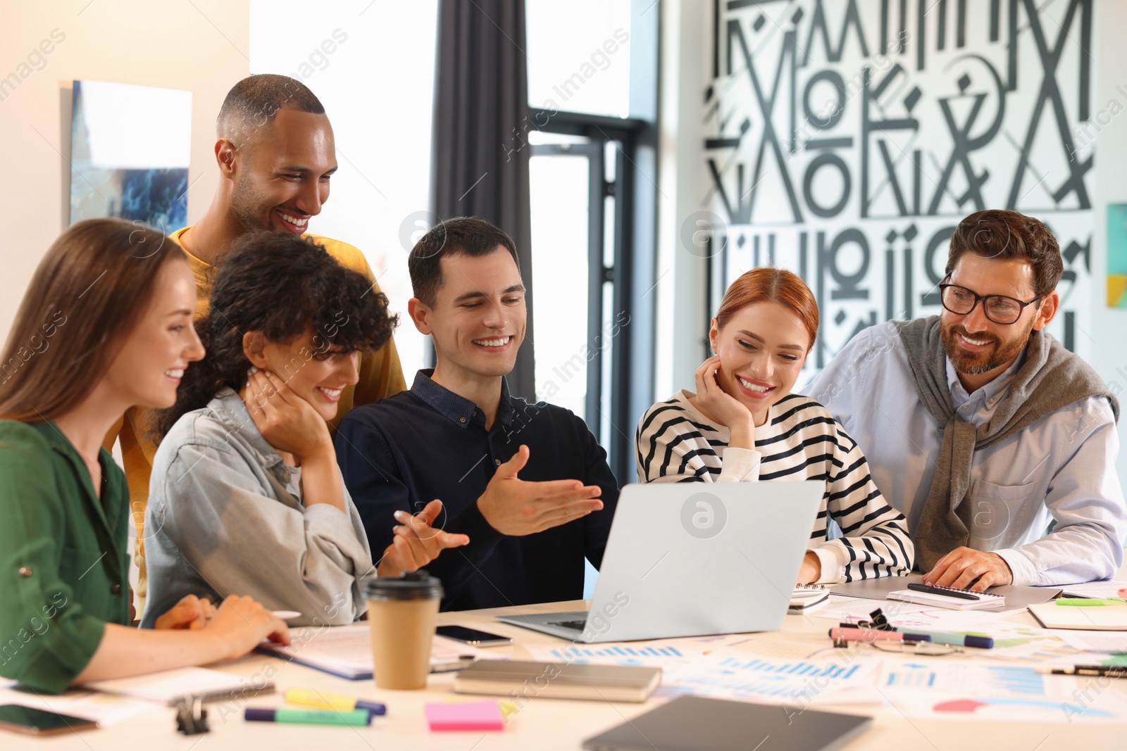 Photo of Team of employees working together at table in office. Startup project