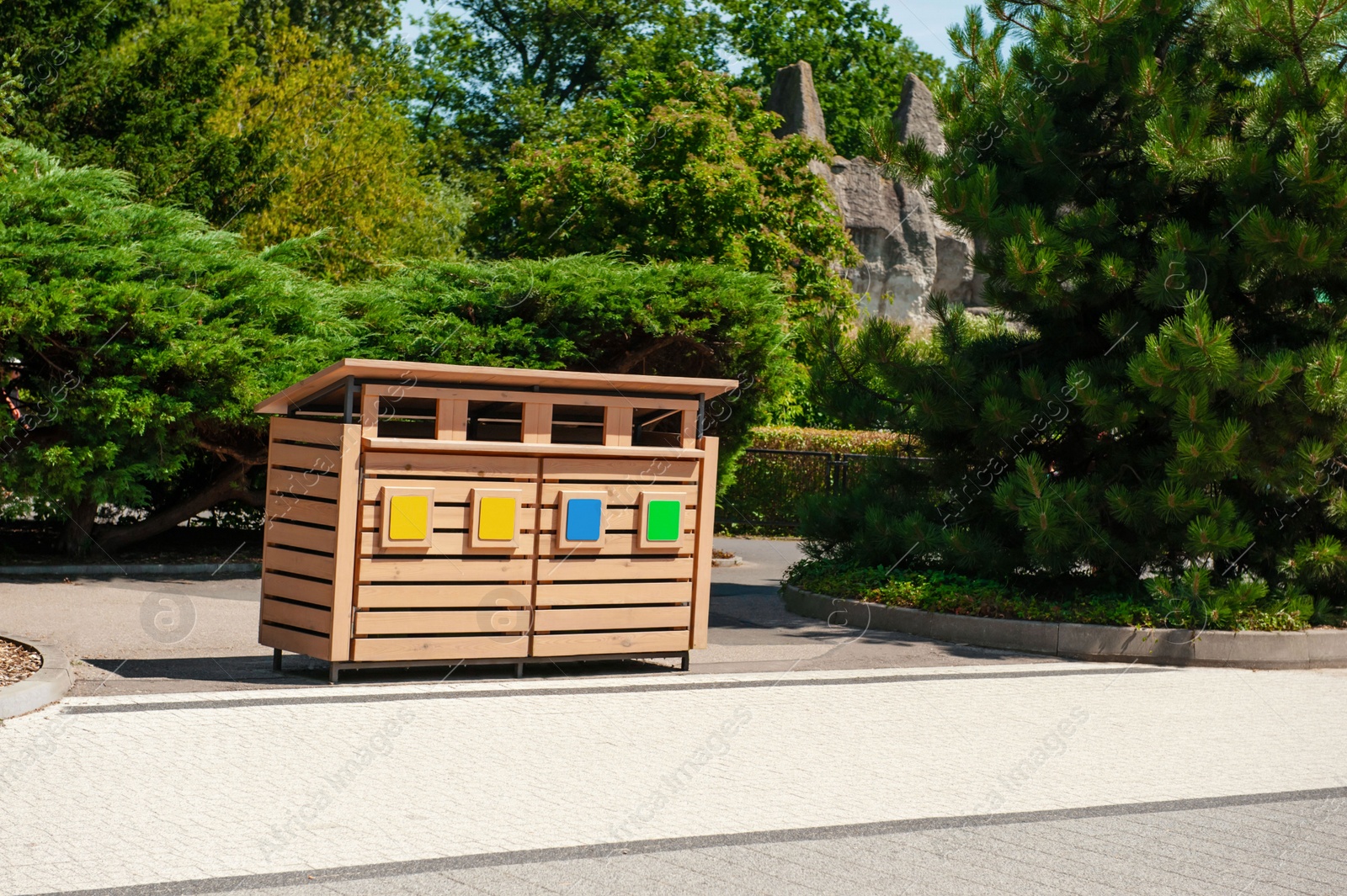 Photo of Wooden recycling bins for waste sorting outdoors