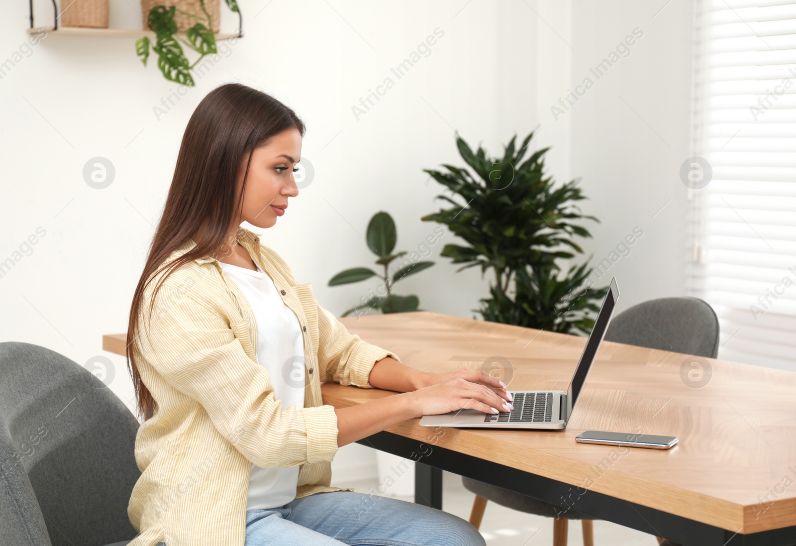 Photo of Young woman working with laptop in office