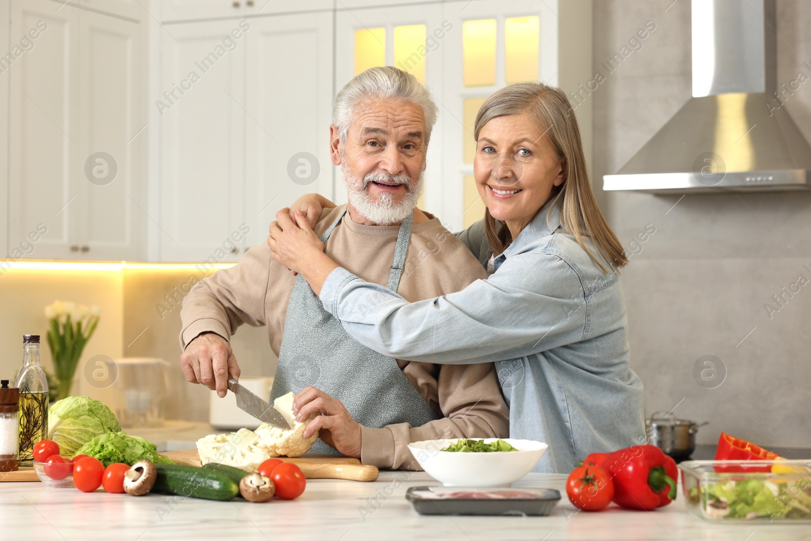 Photo of Happy senior couple cooking together in kitchen