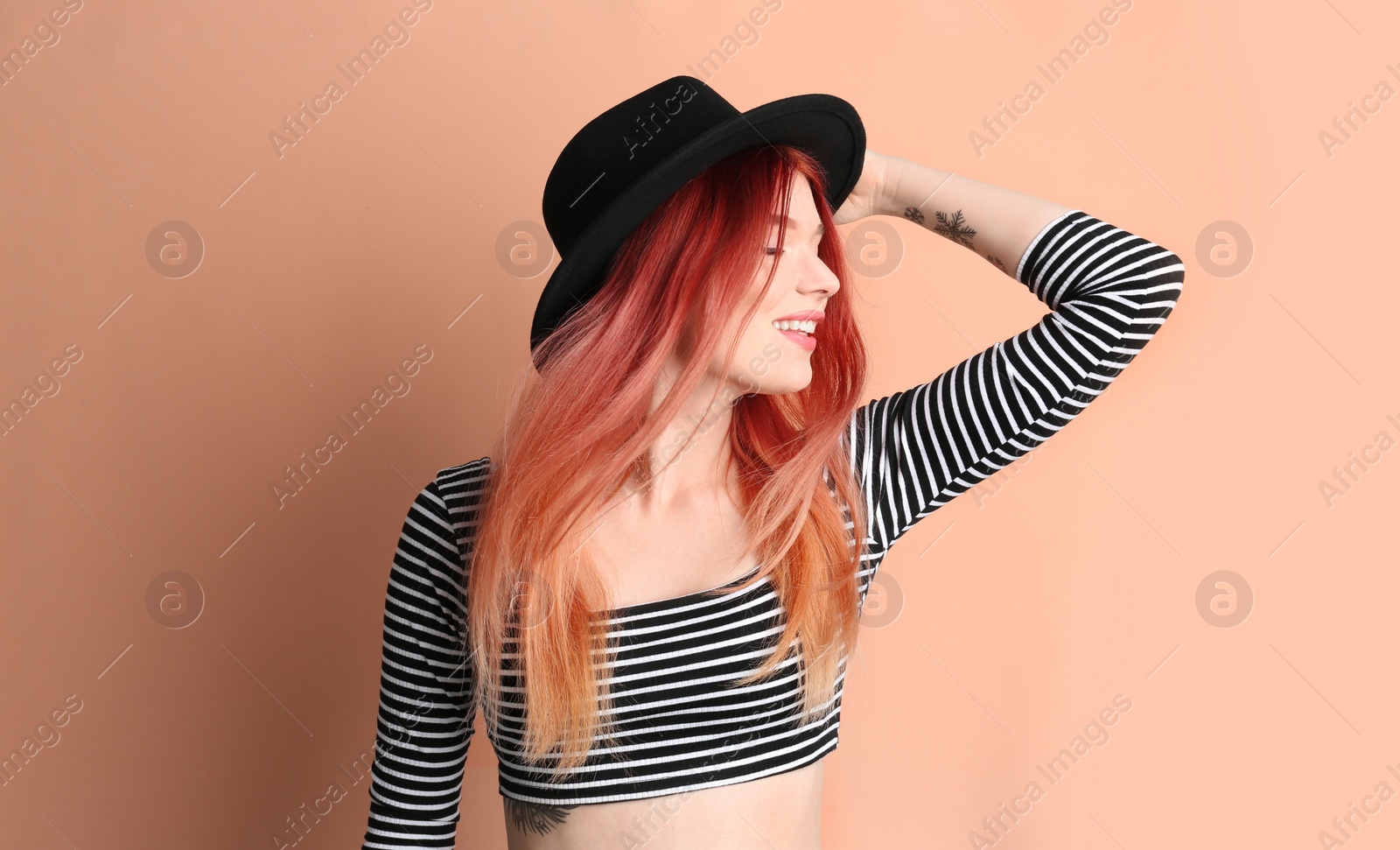 Photo of Young woman with bright dyed hair on pale pink background