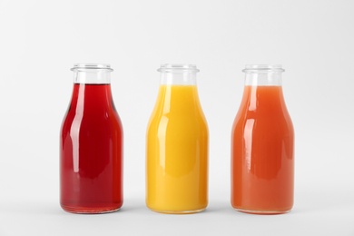 Photo of Bottles with delicious colorful juices on white background