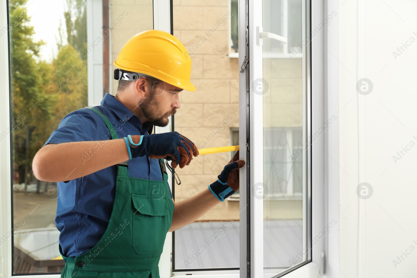 Photo of Construction worker installing new window in house