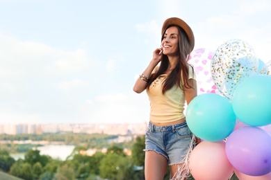 Photo of Beautiful young woman with color balloons outdoors
