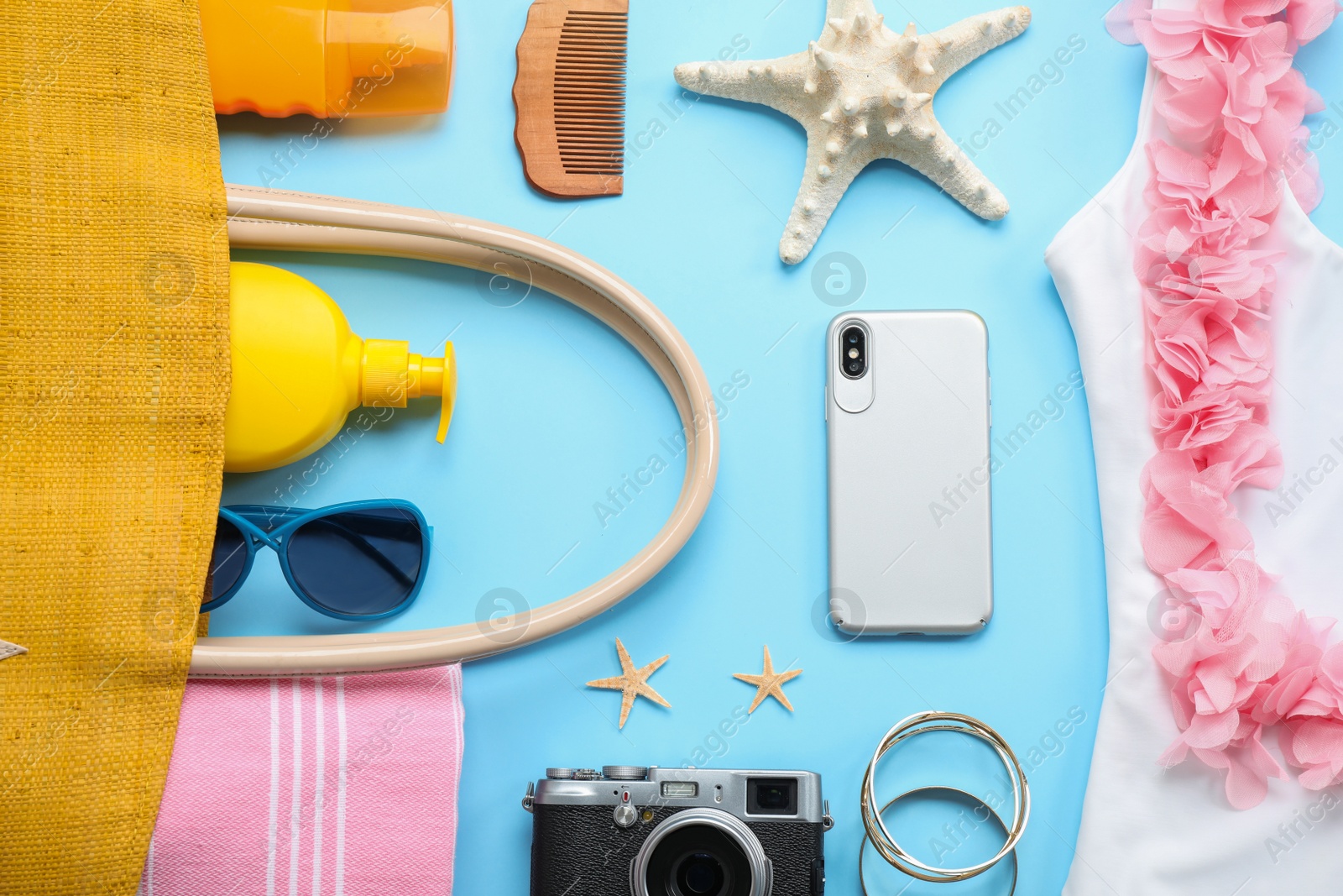 Photo of Flat lay composition with beach accessories on light blue background