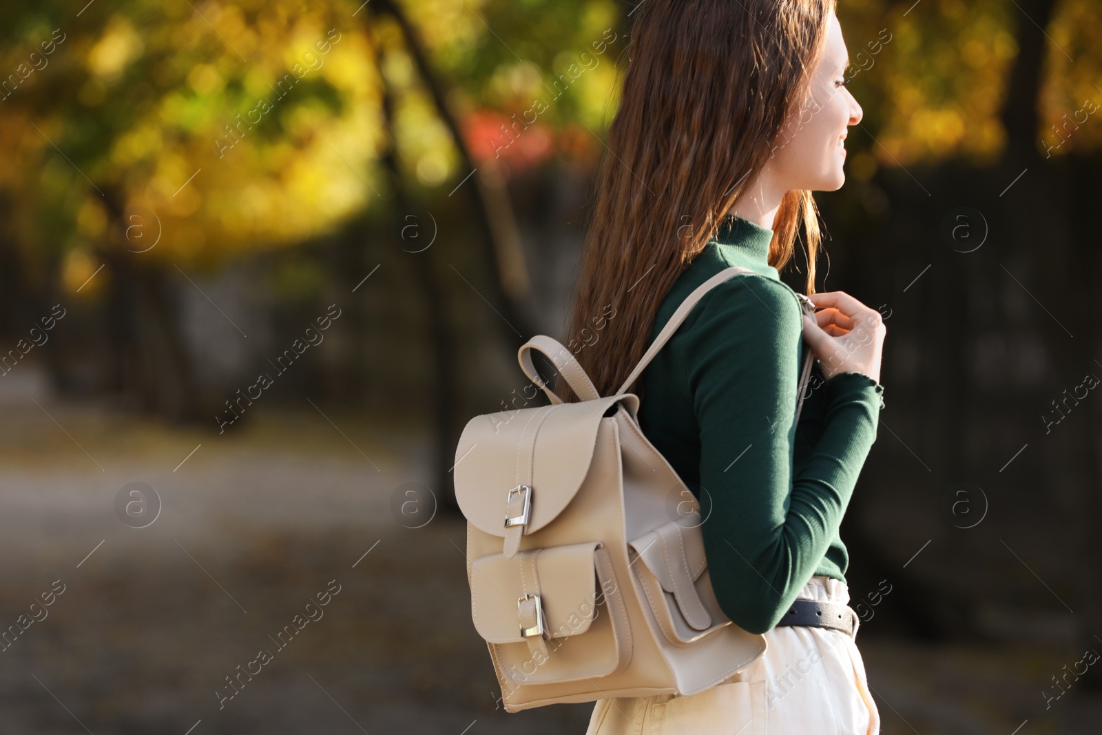 Photo of Young woman with stylish beige backpack on city street, space for text