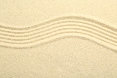 Photo of Zen rock garden. Wave pattern on beige sand, top view