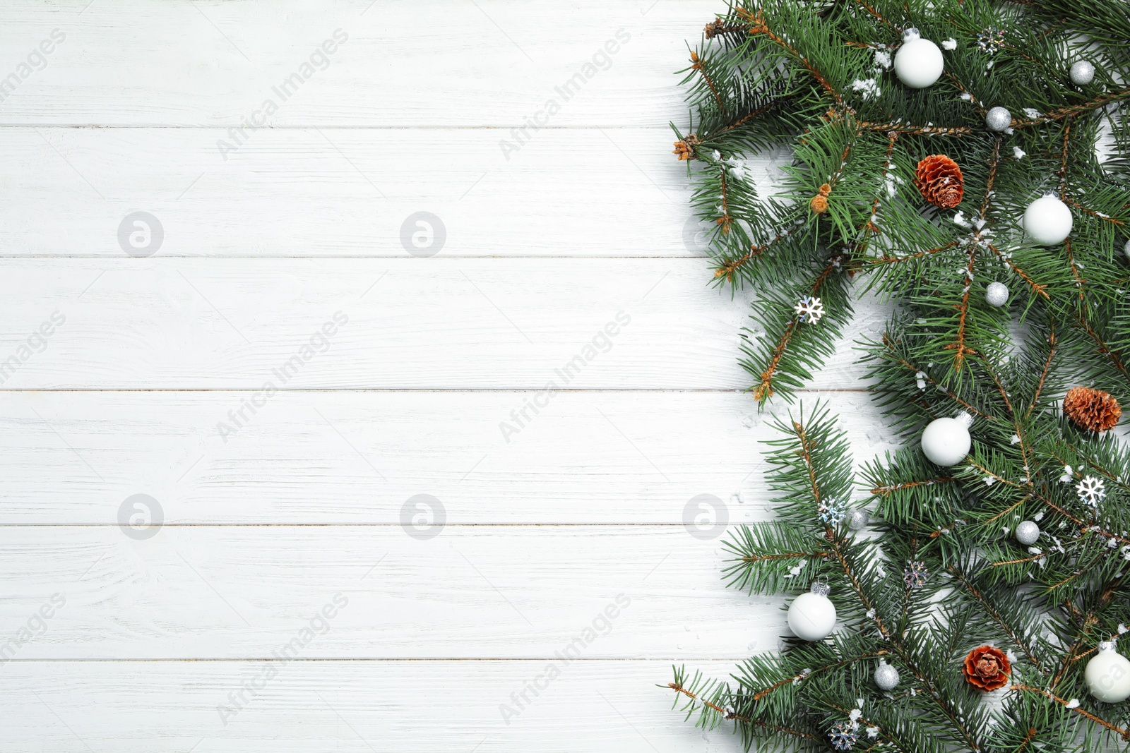 Photo of Christmas decorations on white wooden background, top view. Space for text