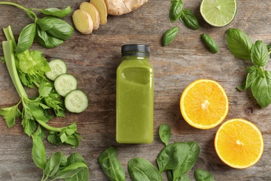 Photo of Flat lay composition with bottle of delicious detox juice and ingredients on wooden background