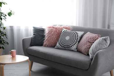 Soft pillows on modern sofa in living room