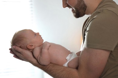 Photo of Father with his newborn son at home