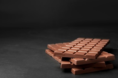 Tasty chocolate bars on grey table, space for text