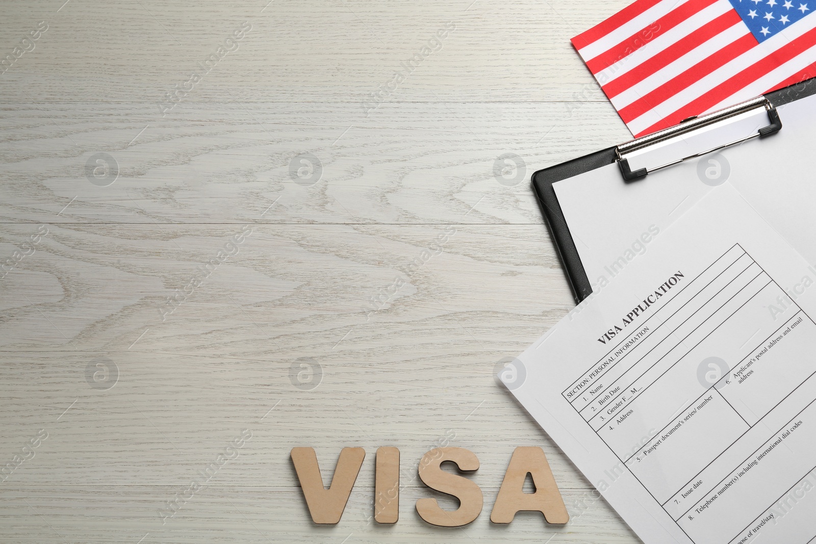 Photo of Flat lay composition with American flag and visa application form on white wooden table, space for text
