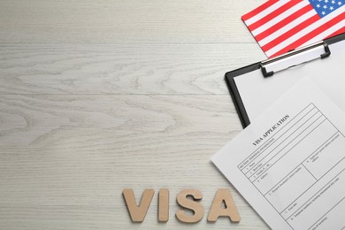 Photo of Flat lay composition with American flag and visa application form on white wooden table, space for text