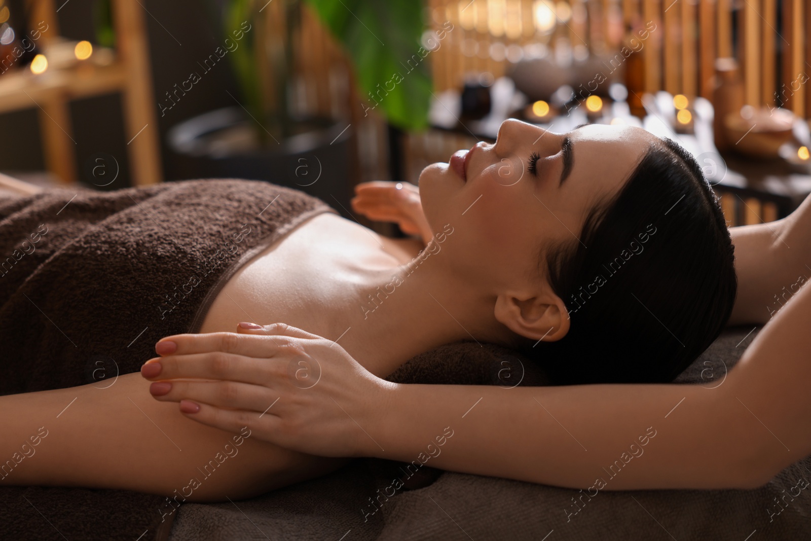 Photo of Spa therapy. Beautiful young woman lying on table during massage in salon