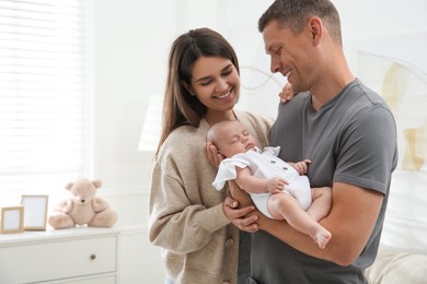 Photo of Happy couple holding their sleeping baby at home