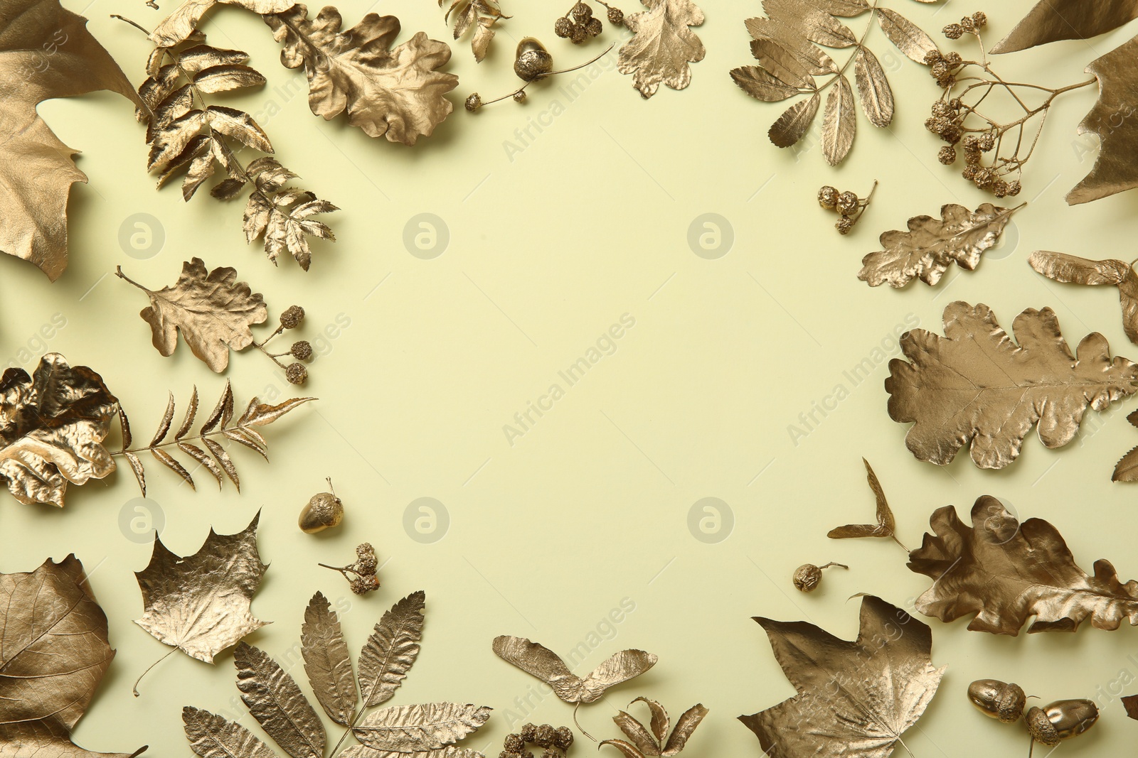 Photo of Frame made of different golden leaves on beige background, flat lay with space for text. Autumn decor