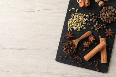 Photo of Different spices on wooden table, top view. Space for text