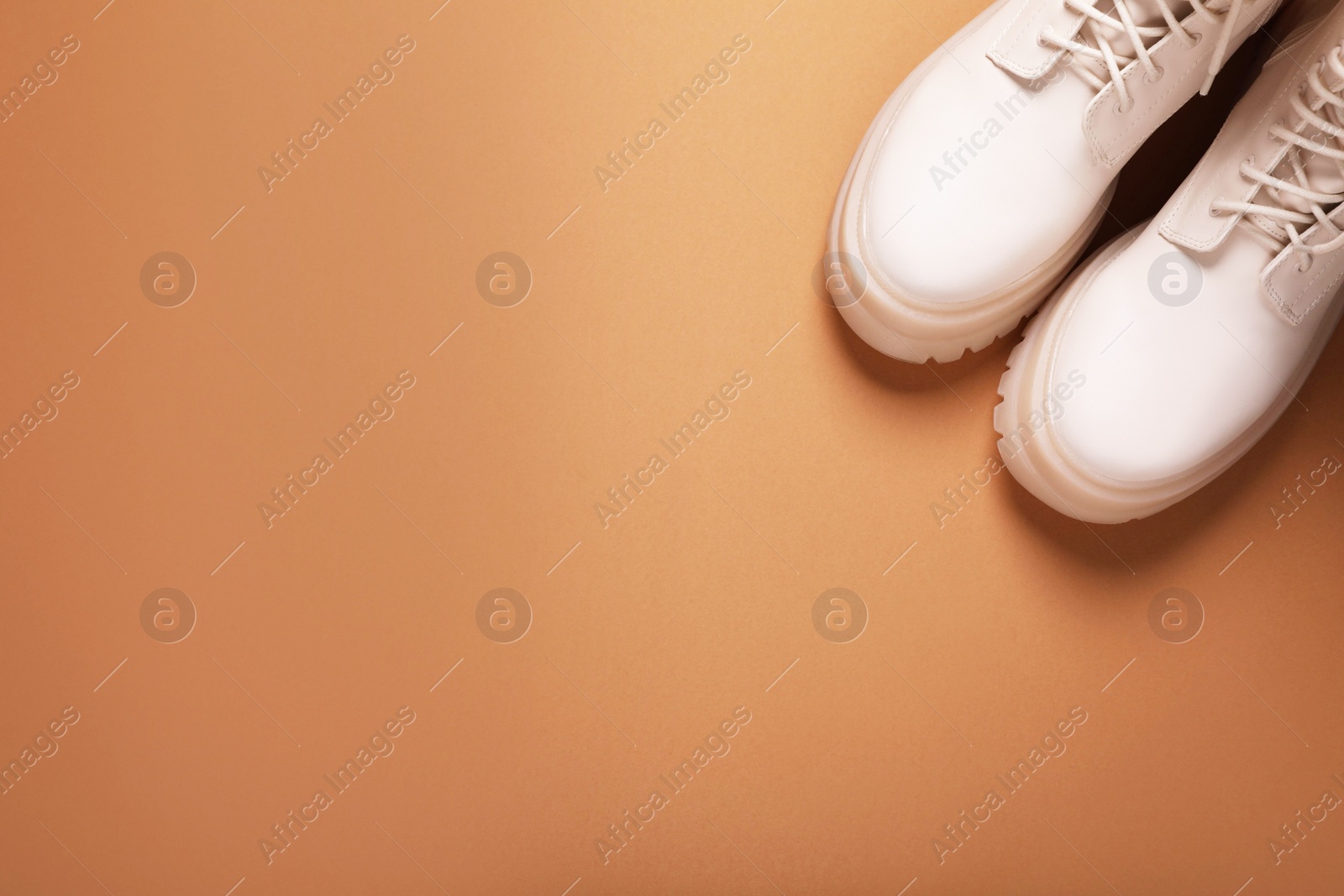 Photo of Pair of stylish leather shoes on light brown background, flat lay. Space for text