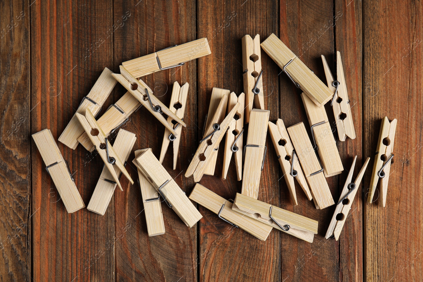 Photo of Pile of clothespins on wooden table, flat lay