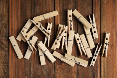 Pile of clothespins on wooden table, flat lay