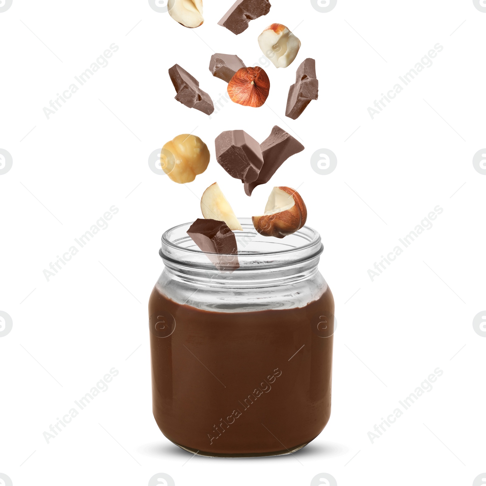 Image of Making yummy chocolate paste. Hazelnuts and pieces of chocolate falling into jar on white background