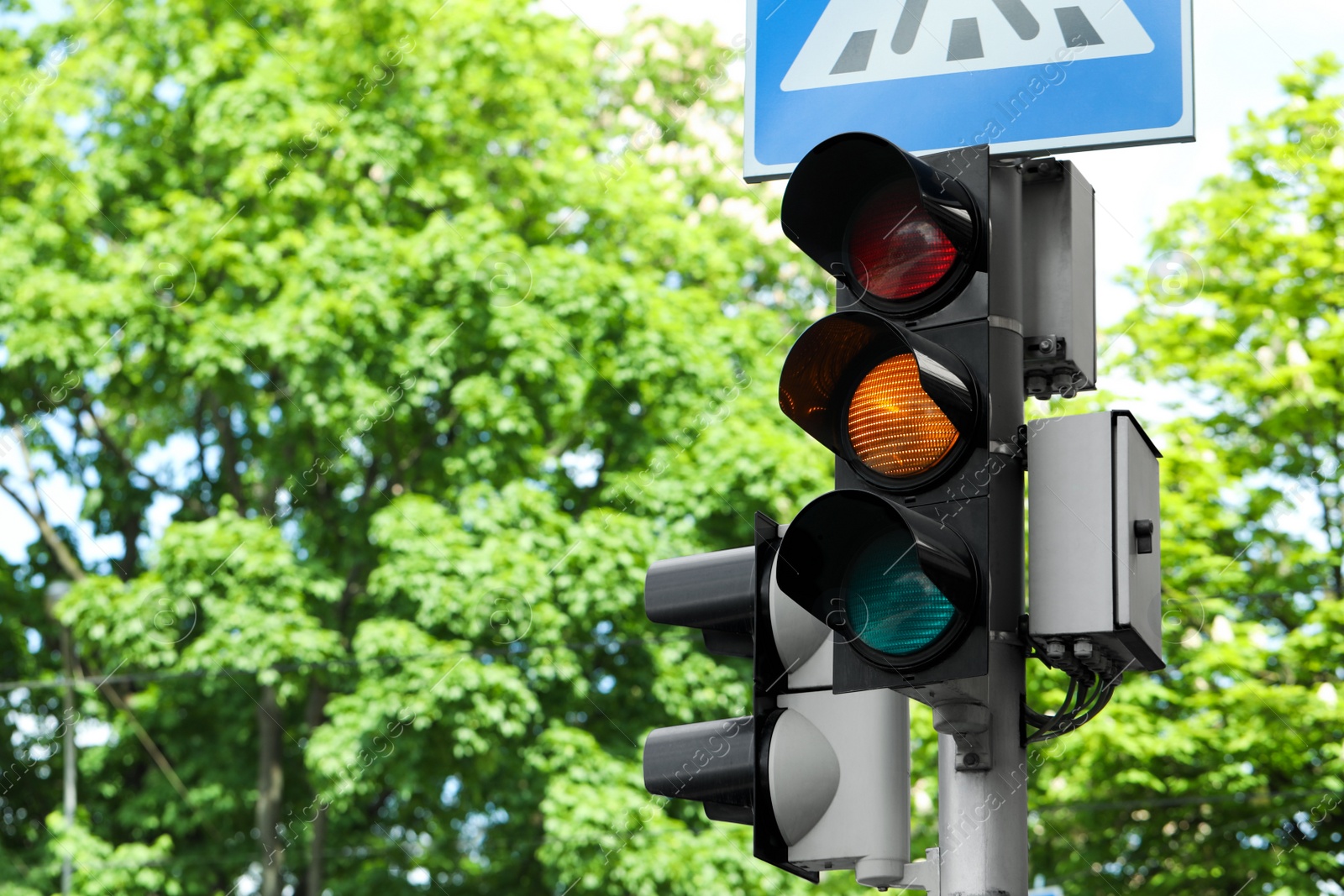 Photo of Post with traffic lights and Pedestrian Crossing road sign outdoors