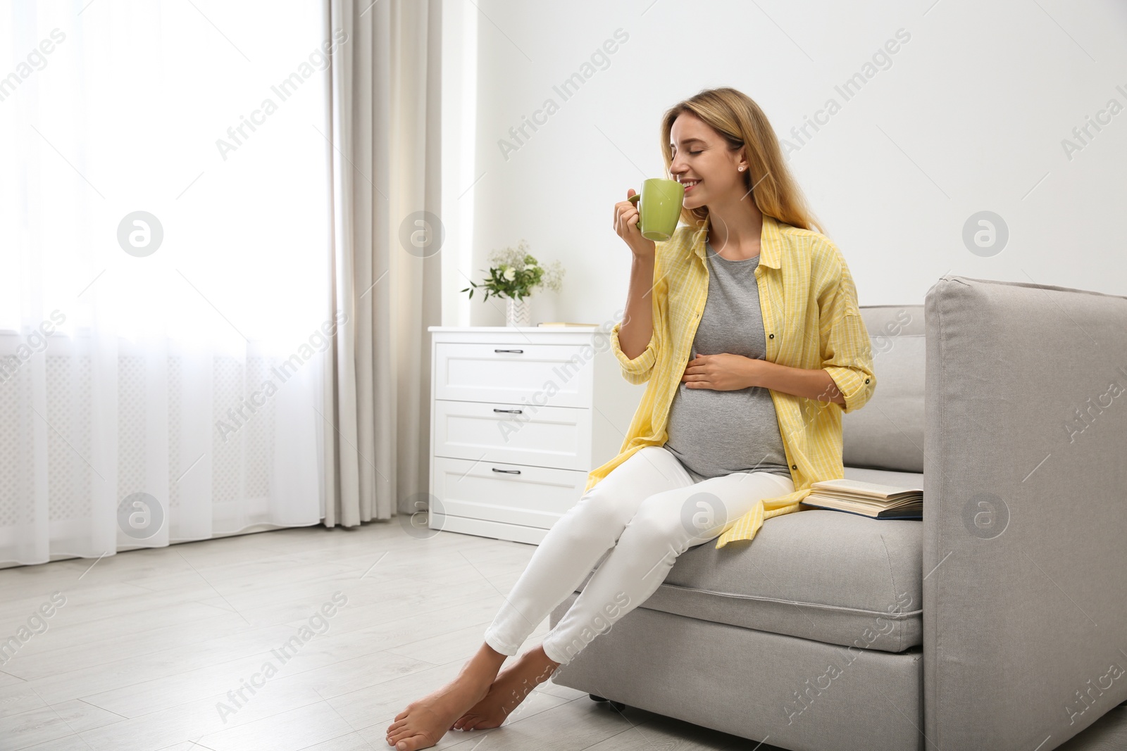 Photo of Beautiful pregnant woman drinking tea at home