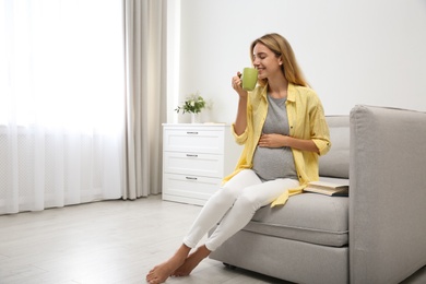 Photo of Beautiful pregnant woman drinking tea at home