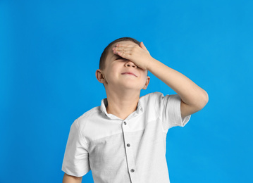 Photo of Portrait of emotional little boy on blue background