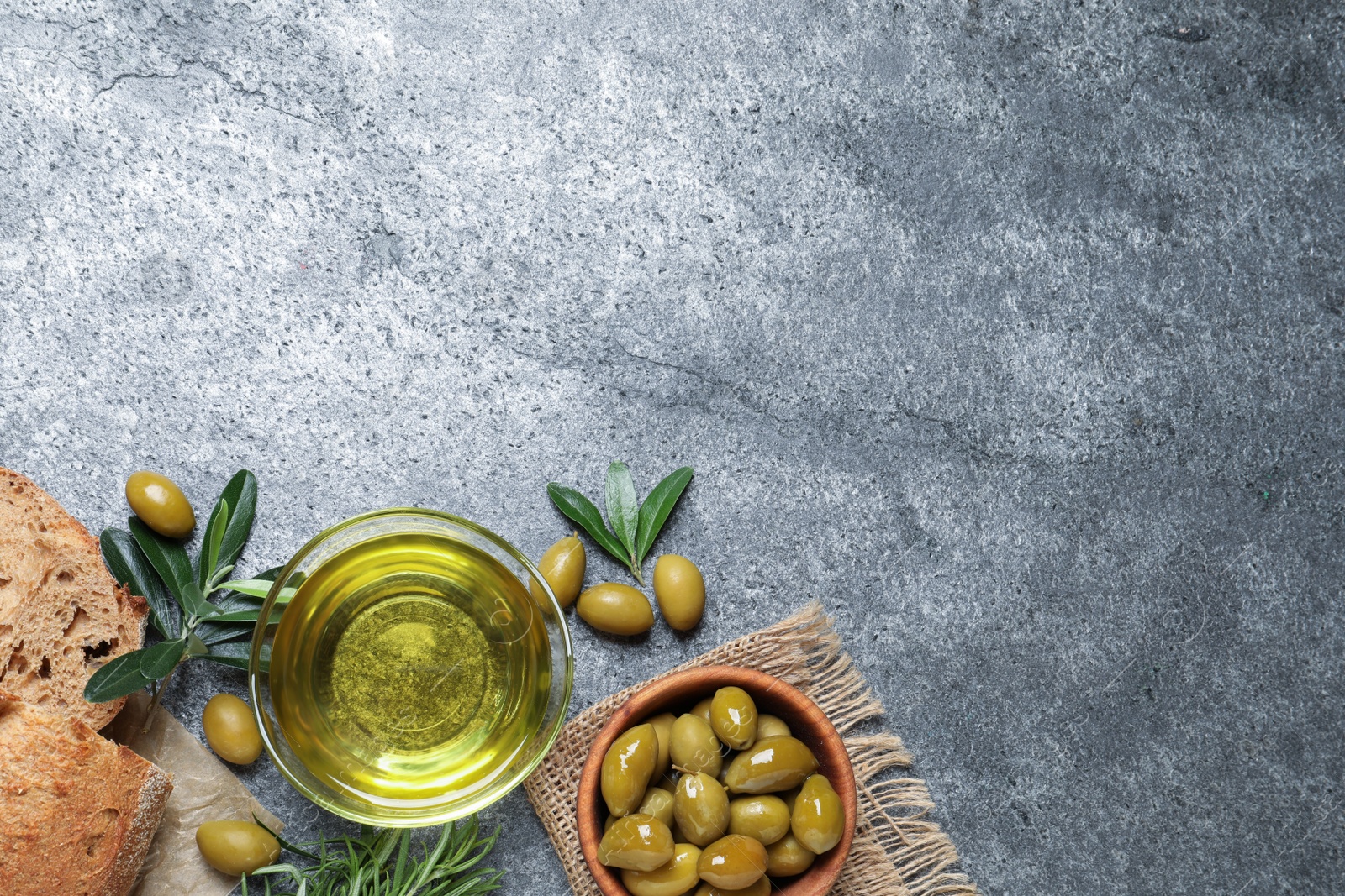 Photo of Flat lay composition with olive oil on grey table, flat lay. Space for text